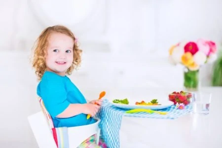 Baby sitting at table in a small high chair