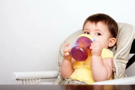 Baby boy drinking juice from a sippy cup