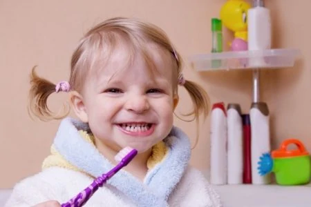Little girl brushing her teeth in the bathroom